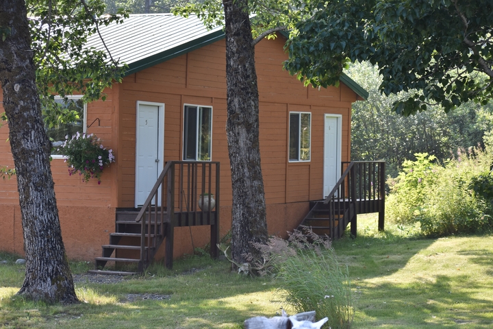       Rustic cabins located in a green wooded area.
  