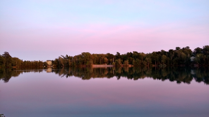       Sunset view over a calm lake with colorful skies.
  