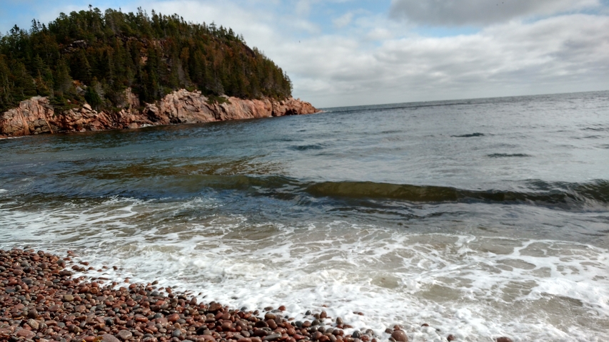       Coastal view with rocky shore and waves.
  