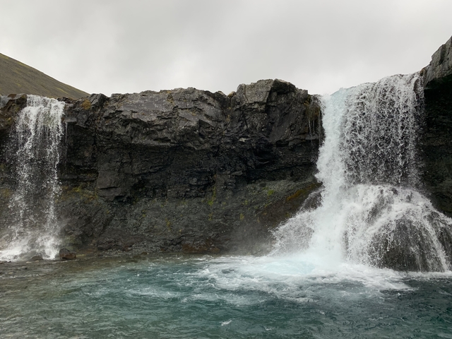 Waterfall cascading over dark rocks.