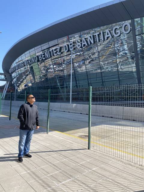 A person standing in front of a stadium with the text 'Santiago' visible.