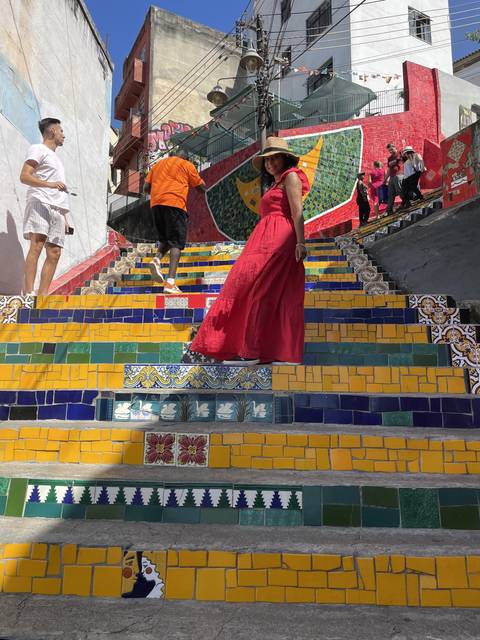       Woman in a red dress walking on colorful stairs
  