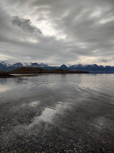       Landscape of mountains and lake with cloudy sky.
  