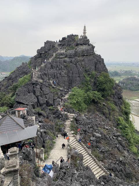 Rocky mountain path with many tourists ascending.
