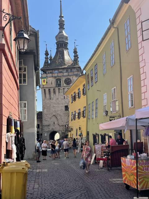 Colorful street scene with people and medieval buildings.