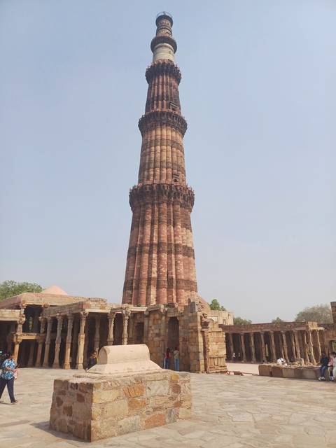       Tall historical minaret with surrounding structures.
  