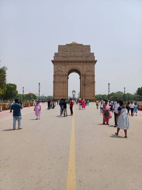       Crowded landmark arch in bustling city.
  
