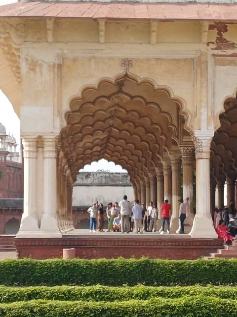 Tourists walking through a series of arches.