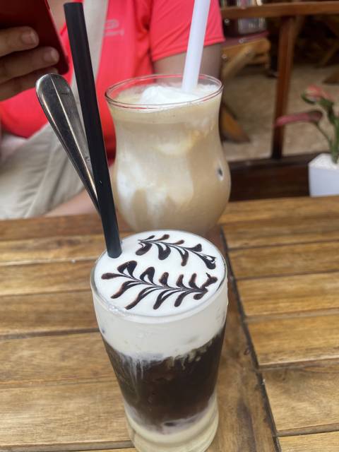 Two glasses of iced coffee with milk foam art.