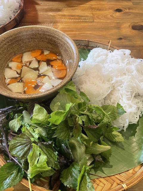 Vietnamese dish with noodles, vegetables, and sauce.