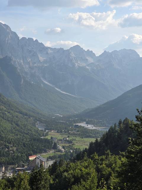       Panoramic view of a valley surrounded by rugged mountains.
  