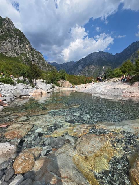 Crystal-clear river flowing through a mountainous region.