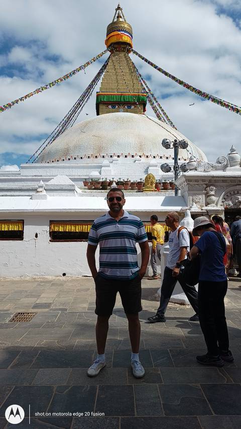       Boudhanath Stupa with people around.
  