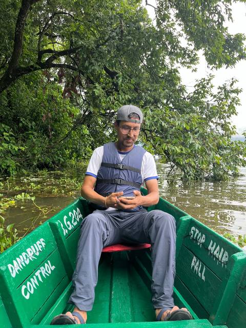       Person in a boat surrounded by lush greenery.
  
