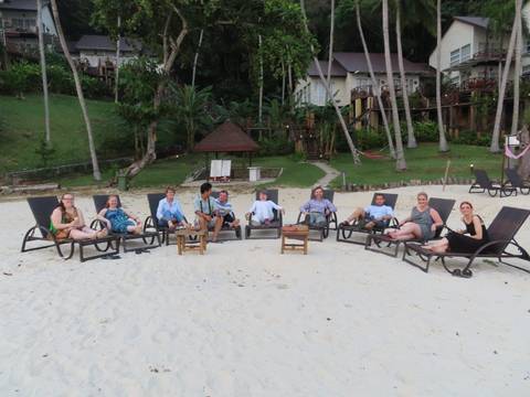       Group of people lounging on beach chairs.
  