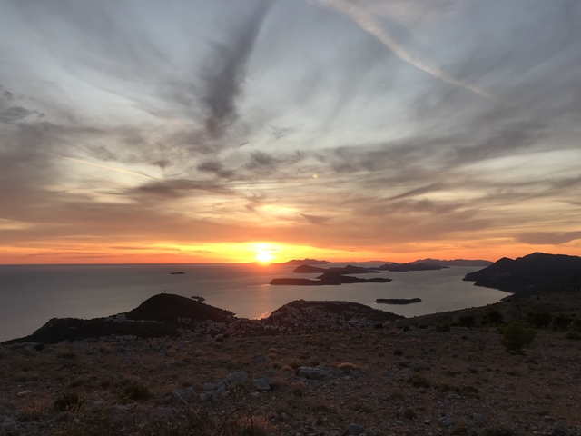       Panoramic view of a sunset over the sea and islands.
  
