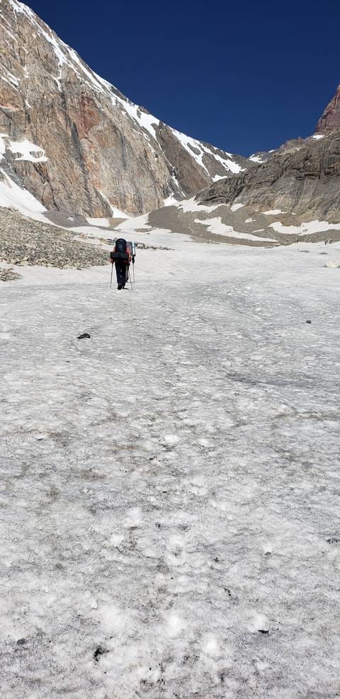      Hiker walking on a vast snowy landscape.
  
