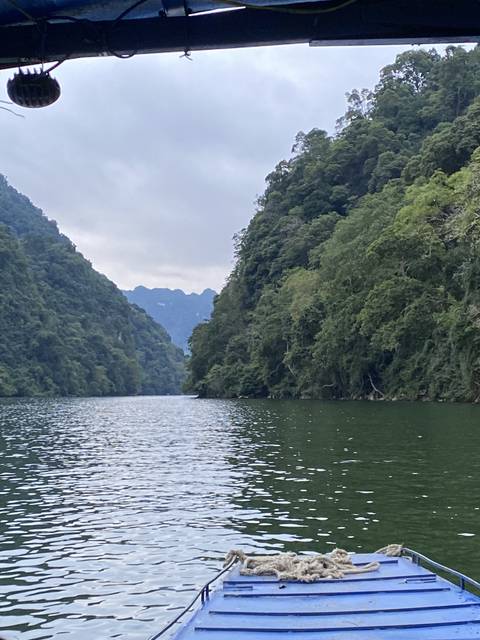       Boat on a lake with forested mountains.
  