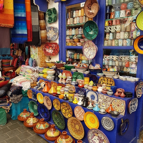       Colorful Moroccan pottery displayed in a market.
  