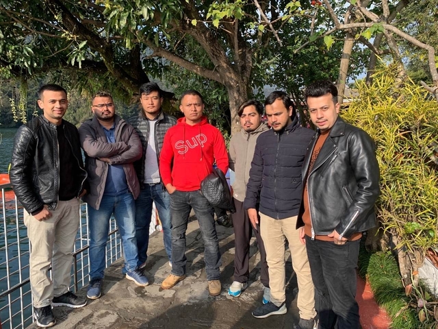       Group of men posing together outdoors.
  