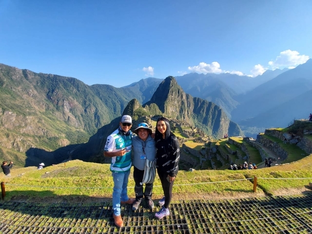 Group of people posing with Machu Picchu in the background.