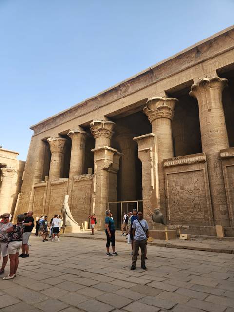 People exploring an ancient Egyptian temple.