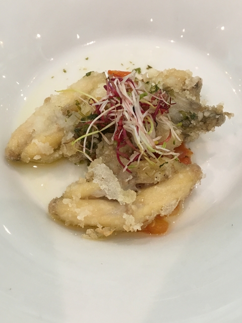 Dish with fried fish and vegetable garnish.