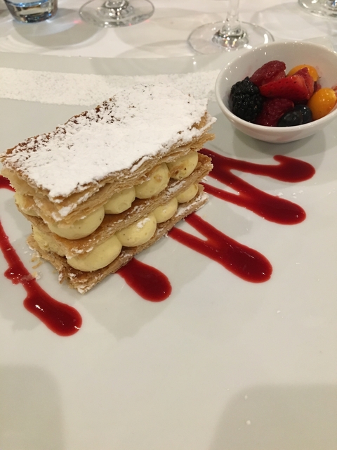 Pastry dessert with cream and raspberry sauce.