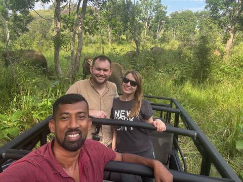 Group of people in a vehicle with green landscape around.