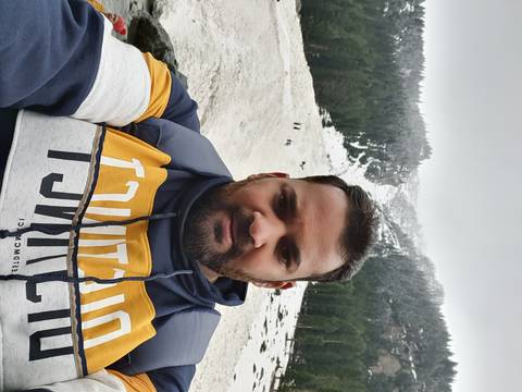 Individual standing in a snowy landscape with trees.