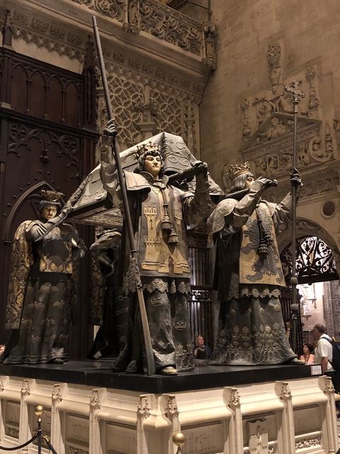       Statues of historical figures in an ornate setting.
  