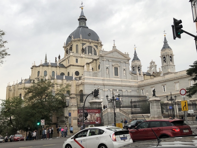       Large cathedral with spires and statues in a city.
  