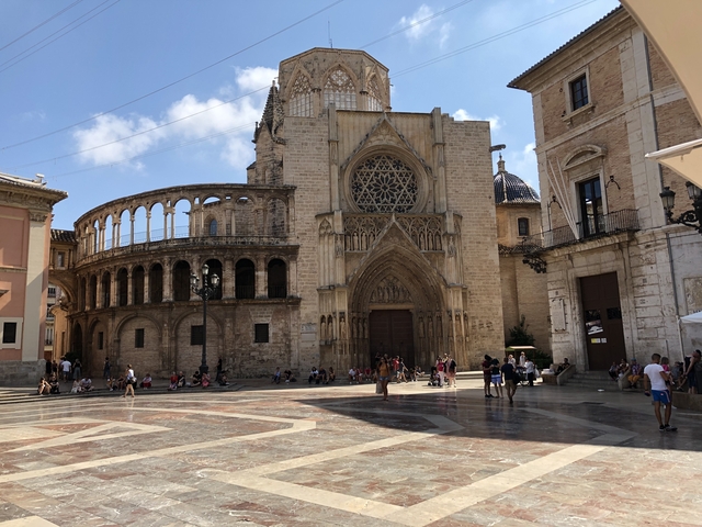       Large cathedral facade with people in a plaza.
  