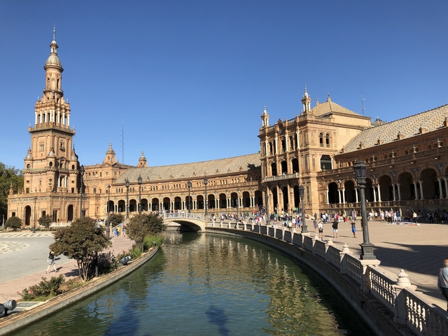       Large historic structure with towers and a canal.
  