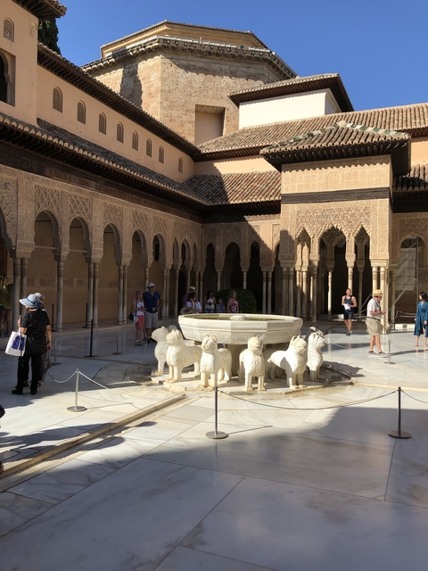       Large historic courtyard with a lion fountain, surrounded by arches.
  
