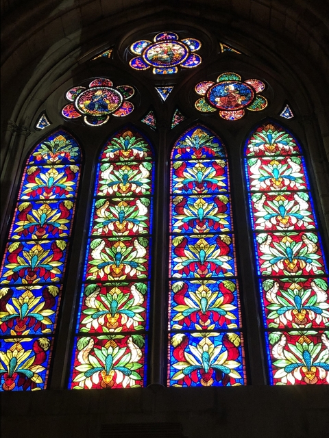       Stained glass windows with colorful patterns in a church.
  