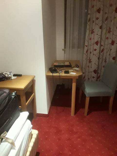 Hotel room with a small desk and chair.