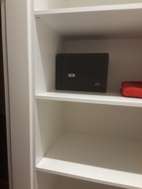 Shelf with a safe and red item.