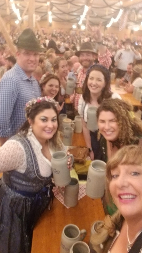Group of people holding beer mugs at a festival.
