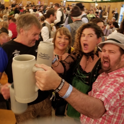 Group of people exuberantly clinking beer mugs.