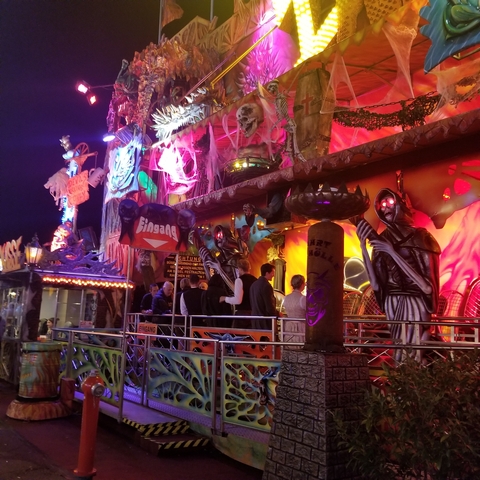 People at an illuminated amusement park attraction.