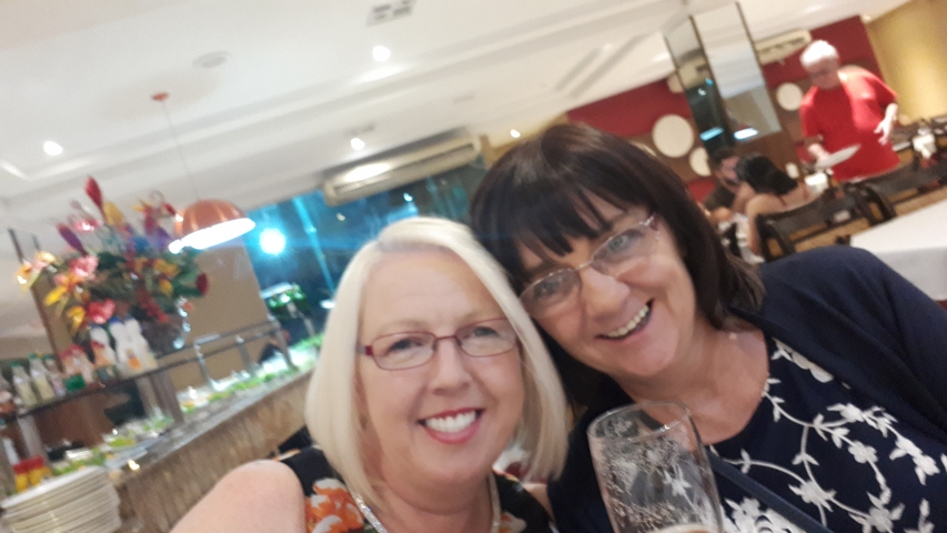 Two women smiling at a restaurant.