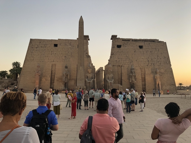       Tourists walking through the monumental Luxor Temple.
  