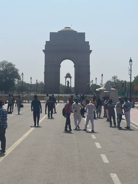       People walking near the India Gate.
  