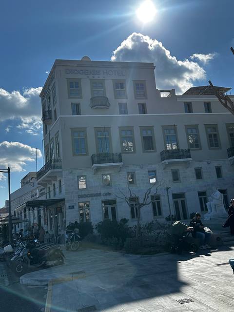Hotel building under bright sunlight with a group of people.