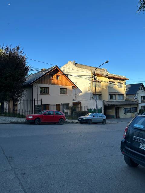       Residential street with cars parked along the curb.
  