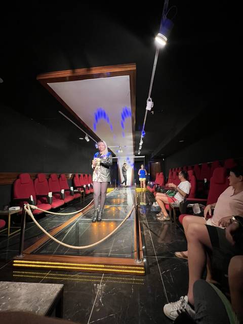       A stage with people sitting in a theater setting.
  