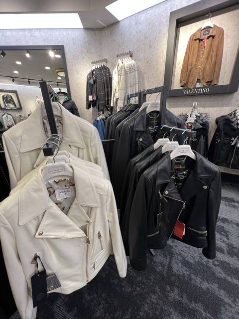       Leather jackets hanging on a rack in a store.
  