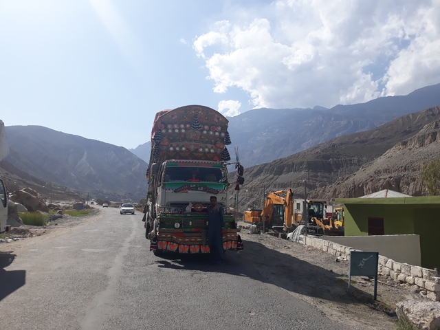 A colorfully decorated truck on a mountainous road.