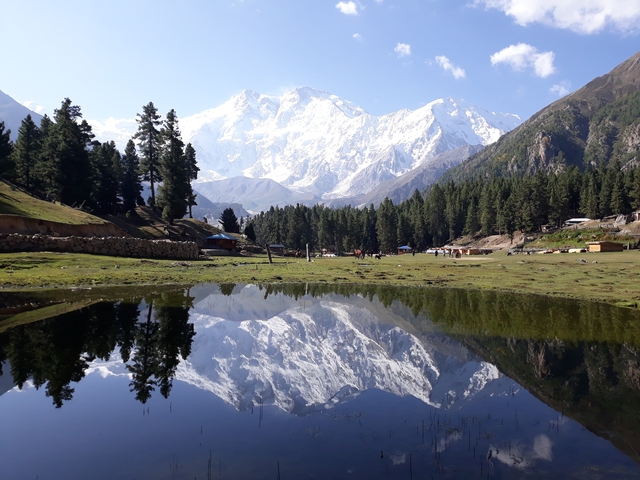 A serene landscape with a mountain reflection in a calm lake.